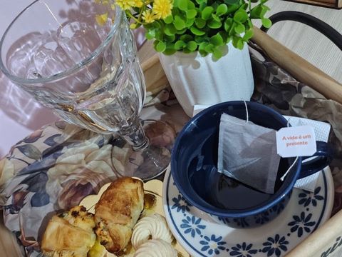 Bandeja de boas-vindas preparada em uma ocasião especial, com chá, água, flores amarelas e petiscos